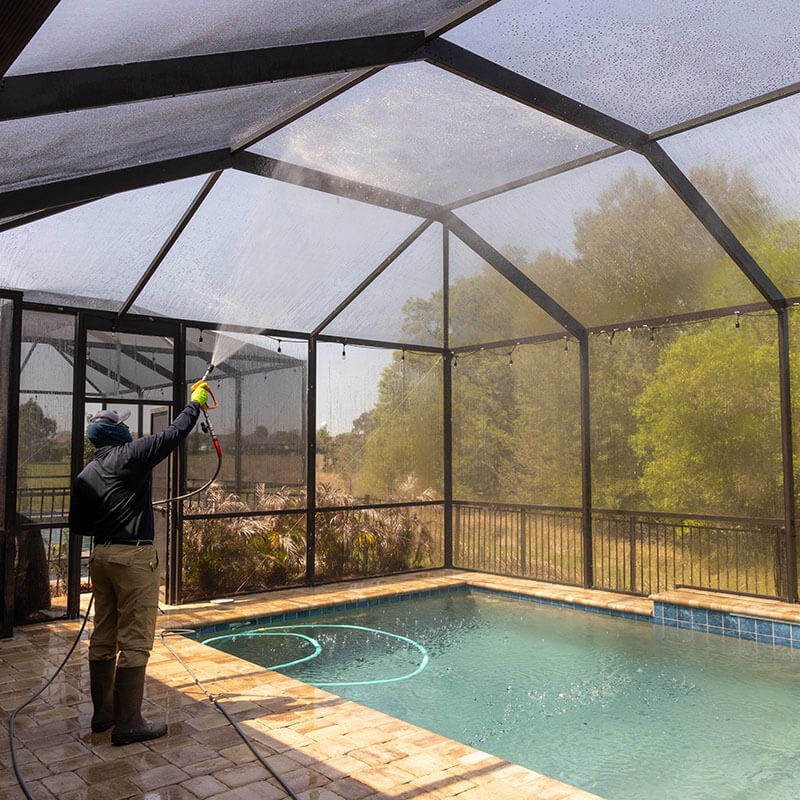 pressure washing professional cleaning glass in pool house