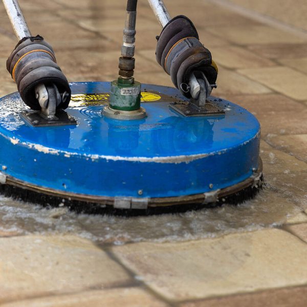 blue pressure washer cleaning pavers